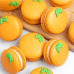 there are many orange macaroons with green leaves on them