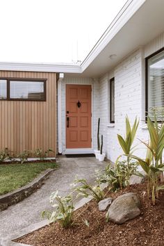 a house with a red door and some plants