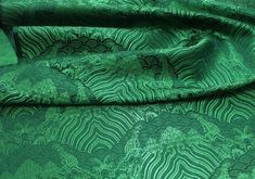 the green fabric has an intricate design on it's side, and is very soft