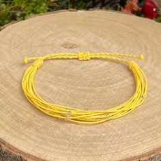 Braided bracelet, made from strands of twisted waxed cord in yellow colour and decoration small silver lined glass seed beads. The bracelet fastens with a sliding knot so you can adjust the size to fit perfectly. Minimum diameter when it's closed is 15-16cm. and the fastening threads allows it to be opened to around 28-30cm. The waxed cord thickness is 1mm. If you need specific size please let us know, custom orders are welcome, feel free to contact us with any questions. All of our bracelets ar Cheap Adjustable Yellow Braided Bracelets, Adjustable Yellow Braided Bracelets, Surf Bracelet, Yellow Colour, Braided Bracelet, Silver Line, Sliding Knot, Braided Bracelets, Friendship Bracelet