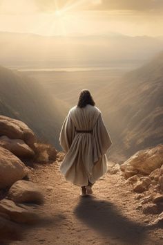 a man dressed in white walking up a hill towards the sun with his hands on his hips