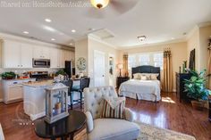 a living room filled with furniture next to a kitchen and breakfast nook area on top of a hard wood floor