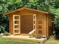 a small wooden shed sitting on top of a lush green field