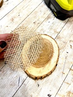 a person is holding a piece of wood with a mesh covering it on the floor