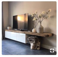 a tv is on top of a wooden shelf