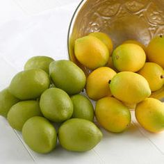 some lemons and limes in a bowl on the floor next to each other