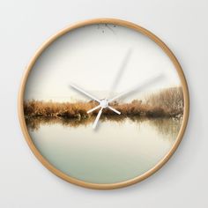 a clock with the reflection of trees in water