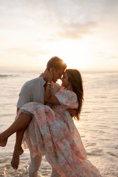 a man carrying a woman on his back at the beach