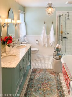 a bathroom with two sinks, a bathtub and a rug on the floor