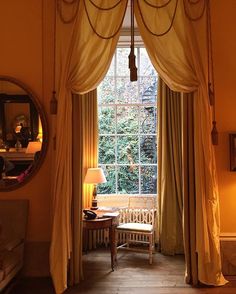 a living room with a large window and curtains