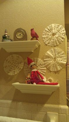 there is a shelf with some ornaments on it and a elf sitting on top of the shelf