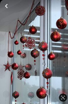 red and gold ornaments hanging from the side of a window