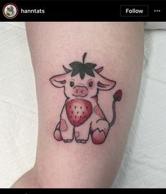 a small tattoo of a cow holding a strawberry