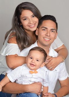 a man and woman pose for a family photo