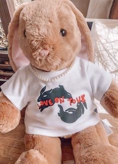 a stuffed rabbit wearing a t - shirt with the words love on tour printed on it