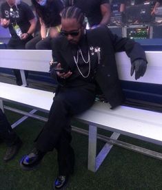 a man sitting on top of a white bench next to another person wearing black shoes