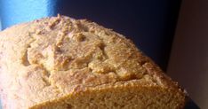 a loaf of bread sitting on top of a blue tablecloth next to a cup