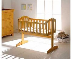 a baby crib in the corner of a room with sunlight coming through the window