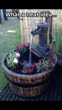 a water fountain in a barrel filled with flowers