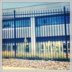 a large building with lots of windows behind a fence