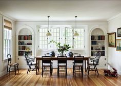 the dining room table is surrounded by chairs and bookshelves