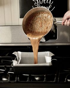 someone is pouring something into a pan on the stove