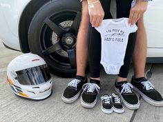 a person sitting on the ground next to a motorcycle helmet and some shirts with words written on them