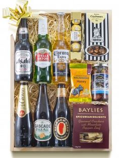 an assortment of beer and snacks in a wooden box with gold ribbon on the top