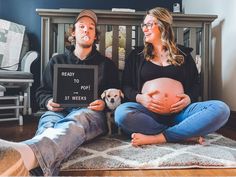 a man and woman sitting on the floor with a sign that says ready to poop st week