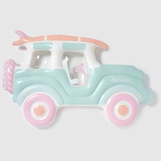 a blue and pink toy car with a surfboard on the roof, sitting against a white background