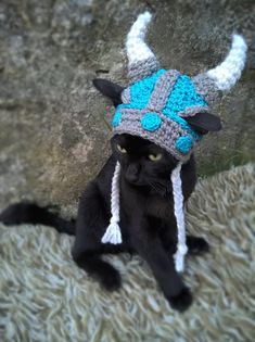 a black cat wearing a knitted hat with horns