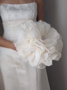 a woman in a white dress holding a bouquet of flowers