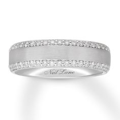 a white gold wedding band with diamonds on the sides and an inscription that reads, feel love