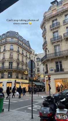 people are walking down the street in front of some tall buildings with balconies