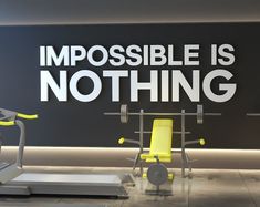 there are two exercise machines in front of a sign that says impossible is not thing