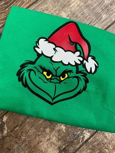 the grin face is wearing a santa hat on top of a green t - shirt