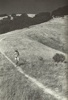 black and white photograph of a person running on a trail