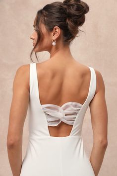 the back of a woman wearing a white dress