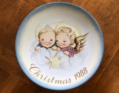 a christmas plate with two angels on it and the words christmas 1908 written in gold