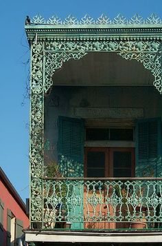 an ornate balcony with green shutters and balconies