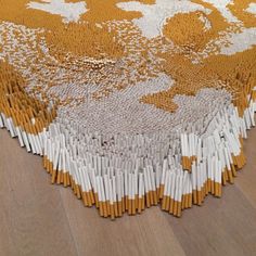 an orange and white rug on the floor with sticks sticking out of it's center