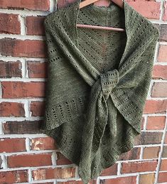 a green shawl hanging on a brick wall