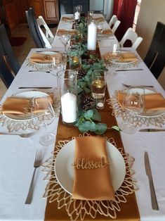 a table set with place settings, candles and napkins