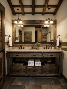 a rustic bathroom with two sinks and large mirrors on the wall, along with wooden cabinetry