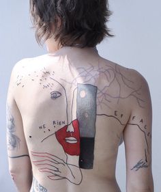 the back of a woman's body with tattoos on it