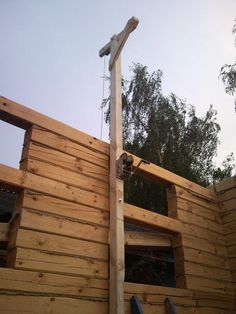 a wooden cross on the side of a building being built with wood planks and nails