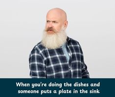 a bald man with a long beard wearing a blue and white checkered shirt is looking at the camera