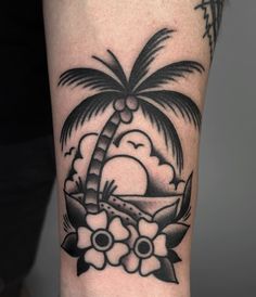 a black and white photo of a palm tree with flowers on the side of a man's arm