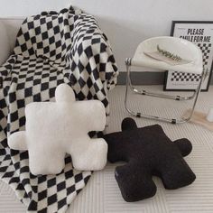 two black and white teddy bears sitting next to each other on the floor in front of a checkered blanket