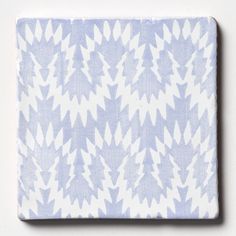 a blue and white square tile with an abstract design on the bottom, in front of a white background